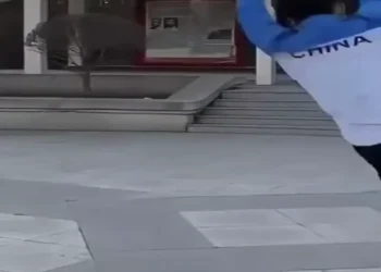 Funny fail video showing a man slipping and falling in public while people react in shock and laughter