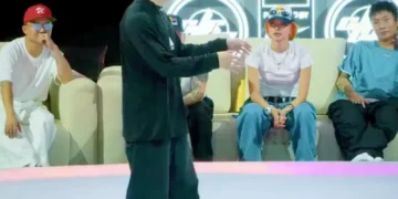 Solo dance battle performance featuring a male street dancer executing sharp movements on a competition stage